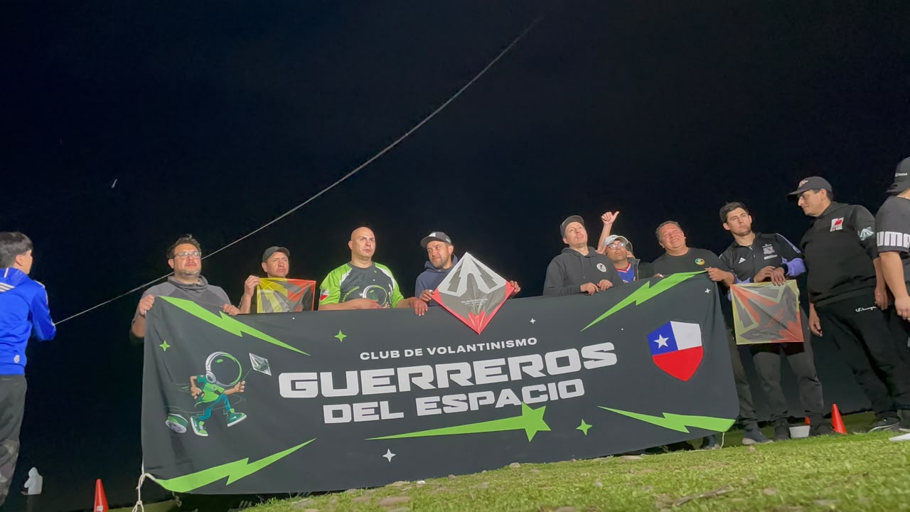 Integrantes sosteniendo la bandera negra y verde del club durante la noche